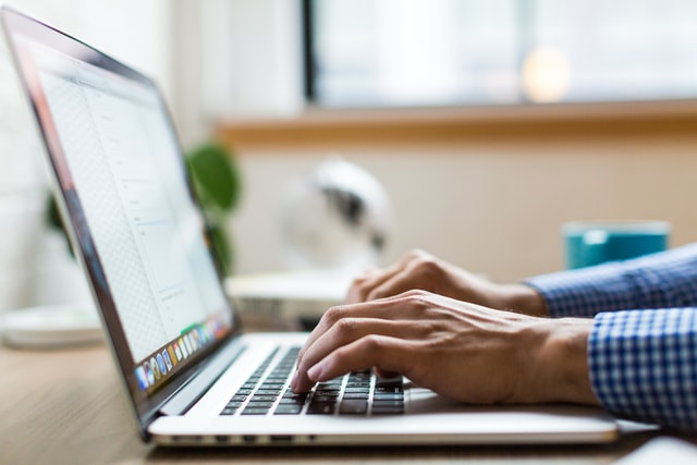 Image of a man writing on a computer